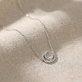Elegant celestial moon necklace worn by female model in natural light